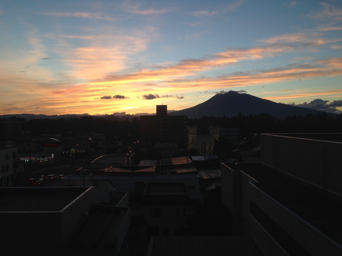 a photo of a sunset in Japan with a view of a mountain against the horizon